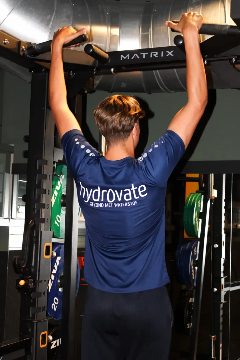Mannelijke sporter in de sportschool met hydrovate reclame op zijn sport shirt.