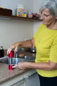 Oudere vrouw die Hydrovate fles gebruikt.